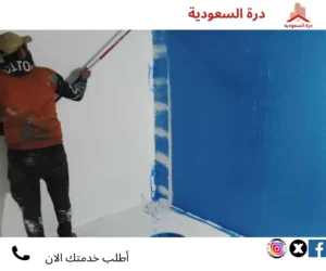 فني يطبق طبقة عزل مائي على أحد الجدران